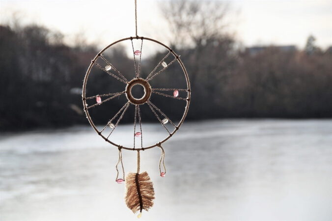 Attrape-Rêves Enfants artisanal avec plume suspendu au-dessus d'un lac gelé en hiver